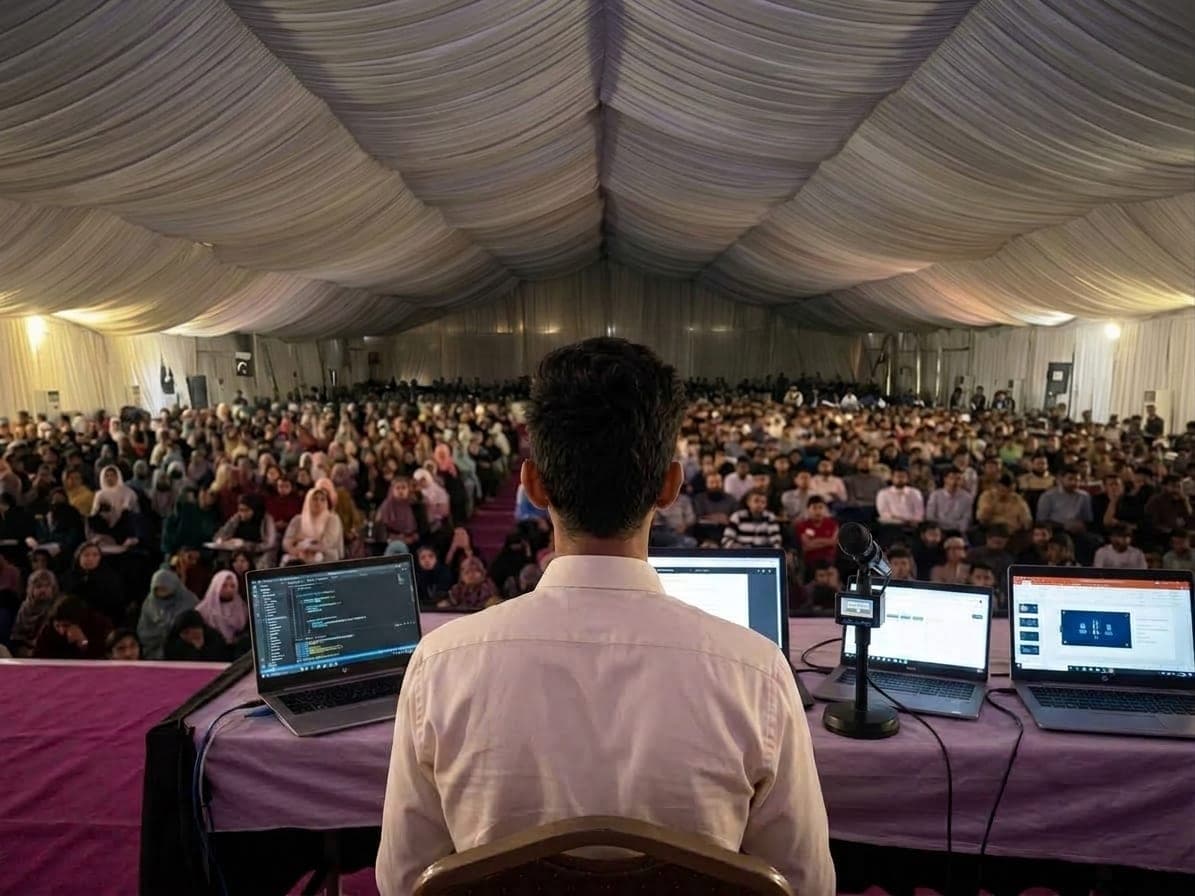 Live coding session on stage with laptops open, teaching at the Governor House IT Initiative
